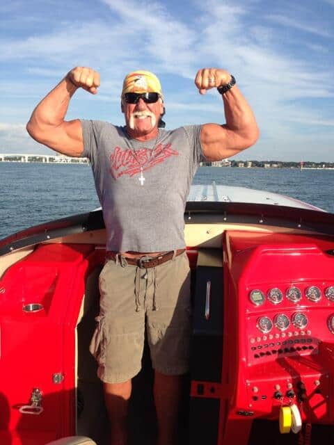 Hulk Hogan posing with his red boat.