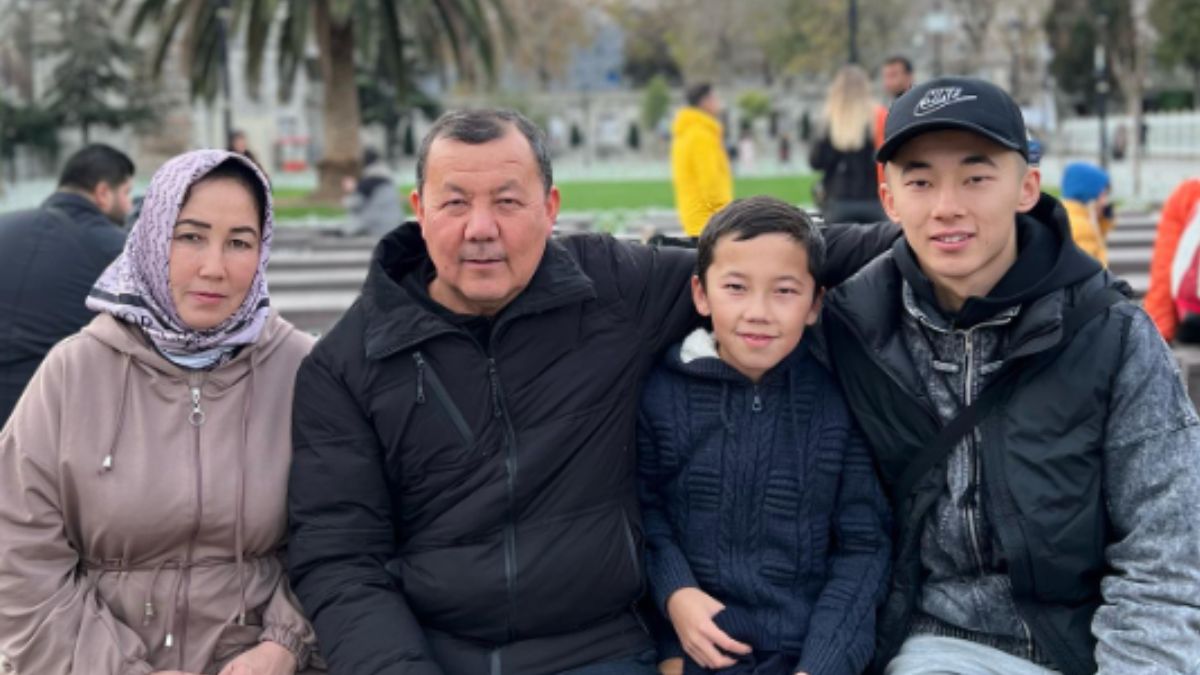Abbosbek Fayzullaev with his family sitting together at an outdoor park