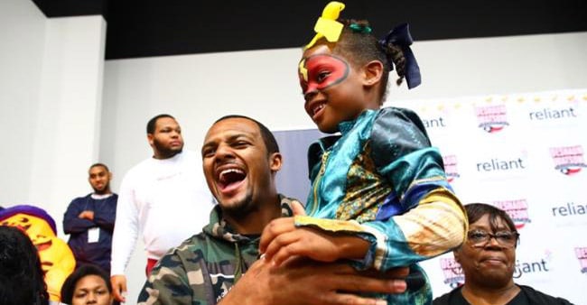 Deshaun Watson Watson holding and laughing with a kid during the charity event