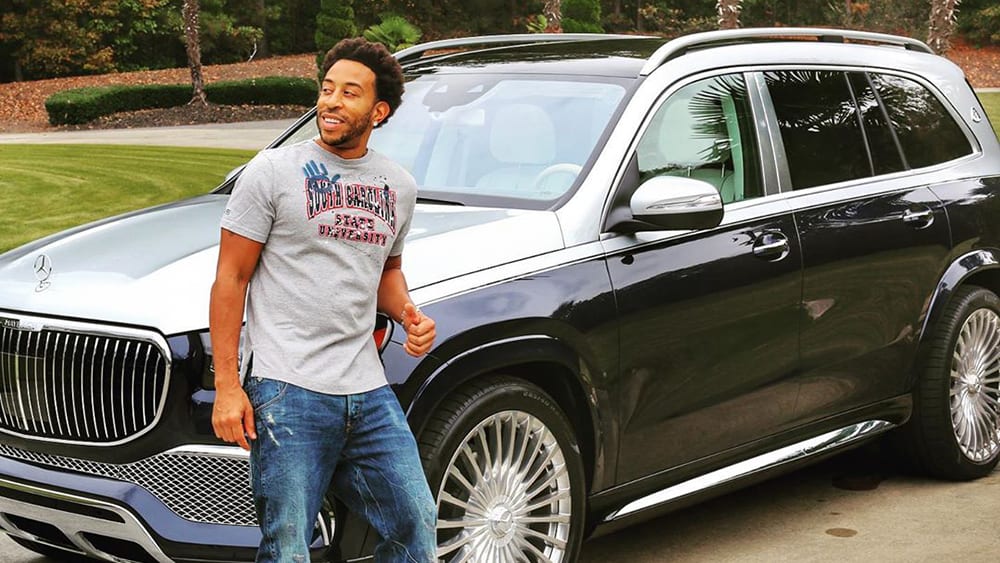 Ludacris standing infront of his Mercedez Maybach