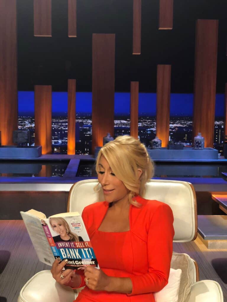 Lori Greiner holding her book, "Invent it, Sell it, Bank it" published in 2014.