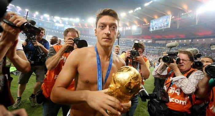 Mesut Ozil surrounded by media with a World cup trophy in his hand after a sweet victory over Argentina in 2014.