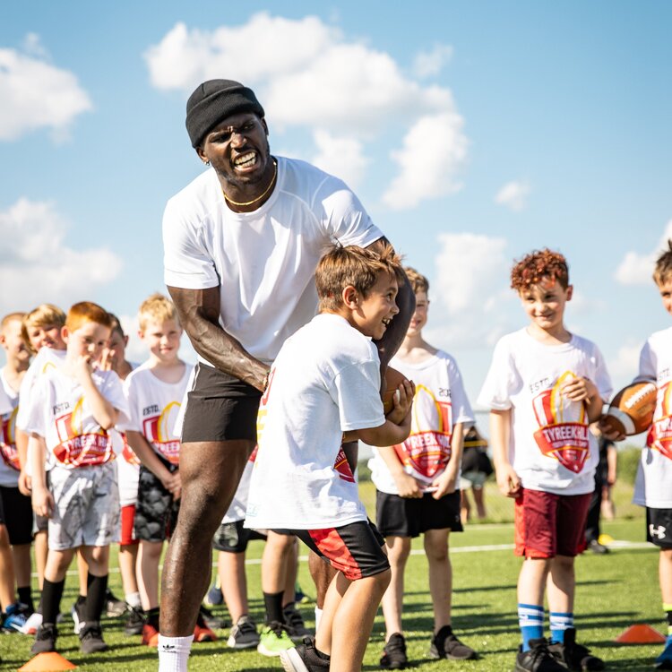 Tyreek Hill with children playing football. (Source: Tyreek Hill Foundation)