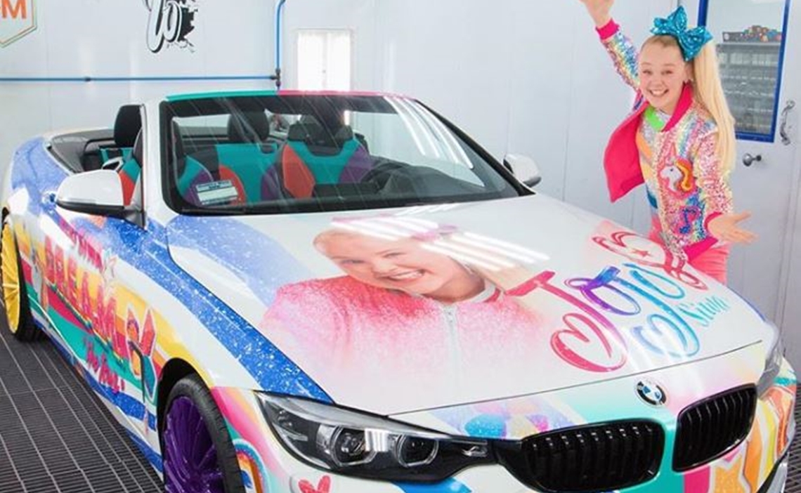 JoJo Siwa posing with her car (Source: Tubefilter.com)